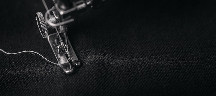 Nadel einer Nähmaschine auf schwarzem Stoff