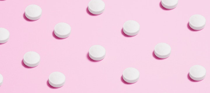 Tabletten auf rosa Hintergrund